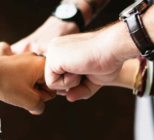 header - Equipe unie qui se retrouvent au centre pour un fist bump