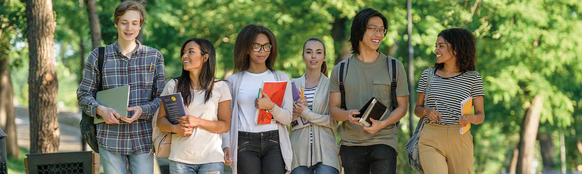 header - étudiants marchant dans un parc en souriant