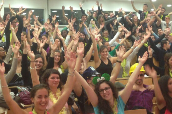 Header - Amphi plein d'étudiants les bras en l'air et souriants