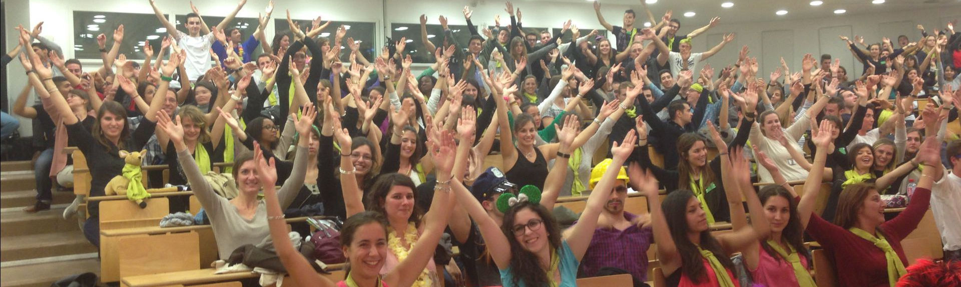Header - Amphi plein d'étudiants les bras en l'air et souriants