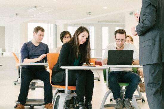 header - jeunes étudiants en salle de coworking suivant un cours concentrés