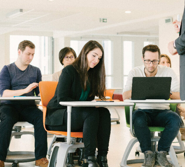 header - jeunes étudiants en salle de coworking suivant un cours concentrés