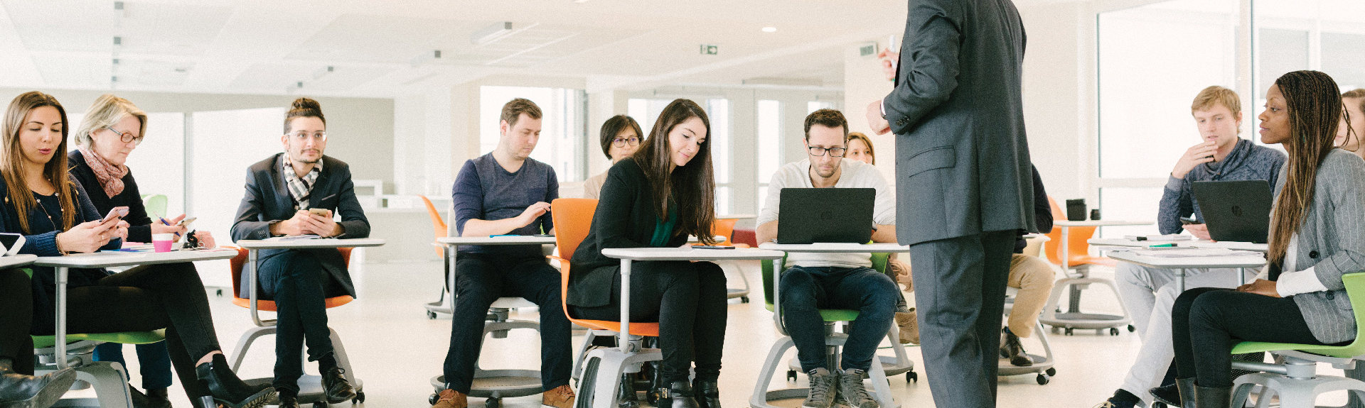 header - jeunes étudiants en salle de coworking suivant un cours concentrés